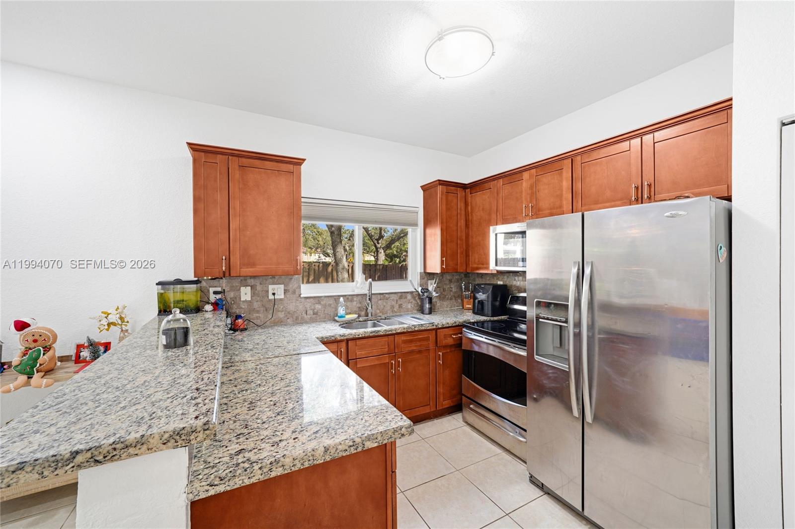 12763 Southwest 50th Street Miramar, FL 33027 - Photo 9 of 38 a kitchen with stainless steel appliances granite countertop a sink refrigerator and microwave