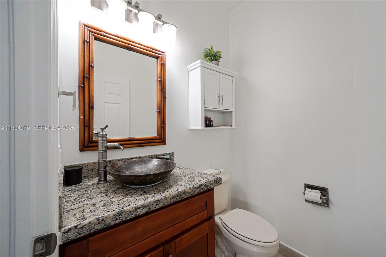 12763 Southwest 50th Street Miramar, FL 33027 - Photo 10 of 38 a bathroom with a granite countertop toilet sink and mirror