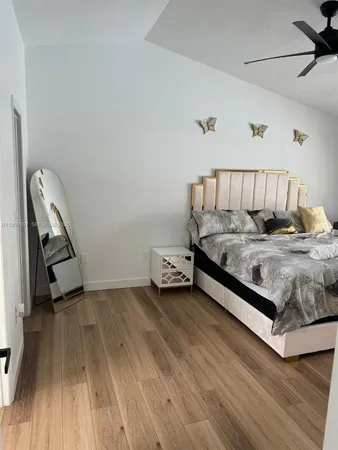 a room with a bed and a wooden floor
