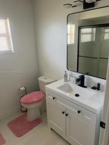 a bathroom with a sink toilet and mirror