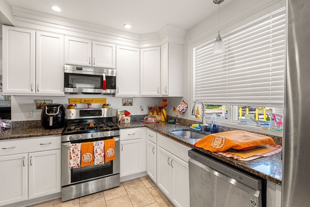 883 Grinnell Street Fall River, MA 02721 - Photo 15 of 41 a kitchen with stainless steel appliances granite countertop a stove a sink and a microwave