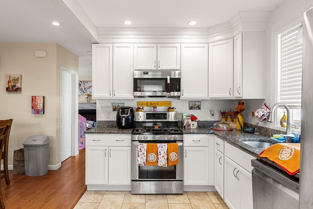883 Grinnell Street Fall River, MA 02721 - Photo 16 of 41 a kitchen with stainless steel appliances granite countertop a stove a sink and a microwave