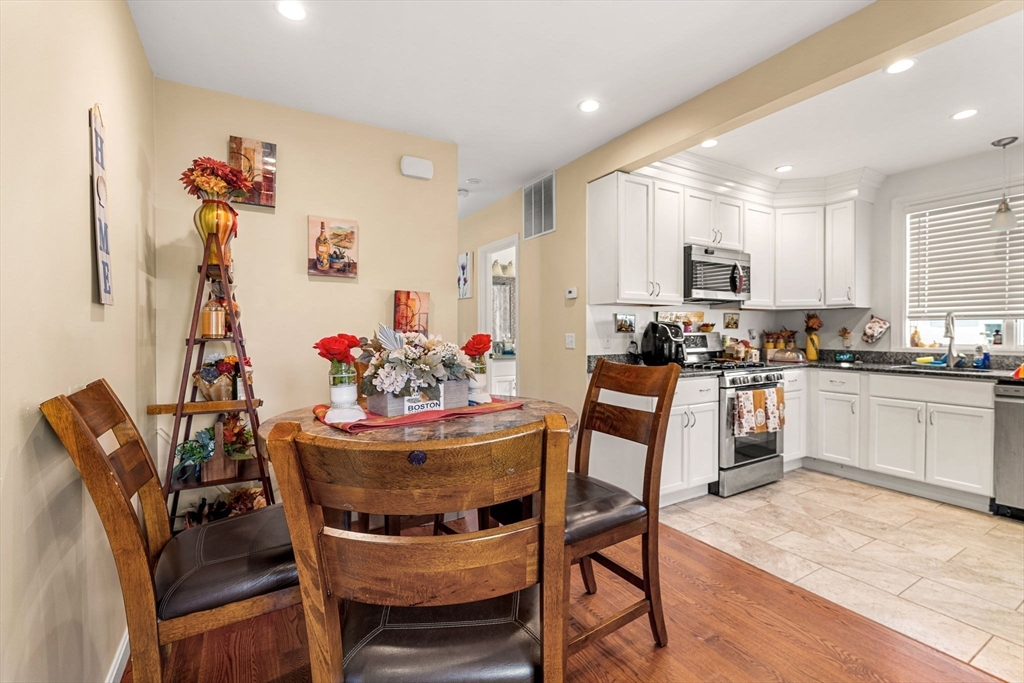 883 Grinnell Street Fall River, MA 02721 - Photo 19 of 41 a kitchen with stainless steel appliances kitchen island granite countertop a dining table and chairs