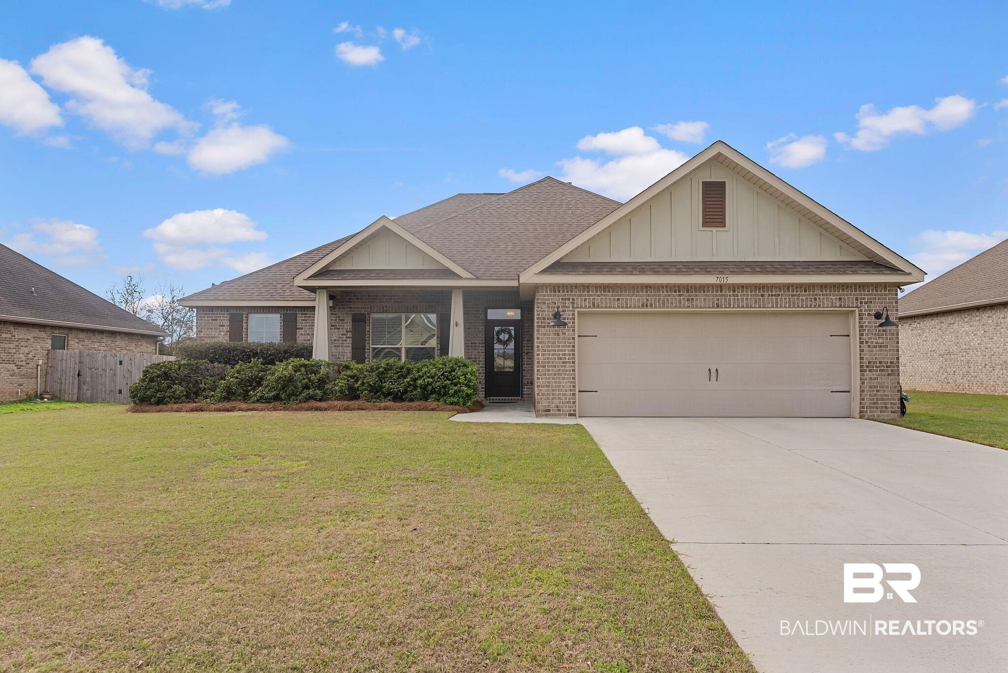7015 Rocky Rd Loop Gulf Shores, AL 36542 - Photo 1 of 41 View of front facade featuring brick siding, an attached garage, concrete driveway, and board and batten siding