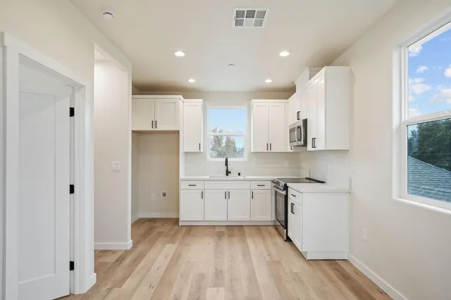 a kitchen with a sink a refrigerator and window