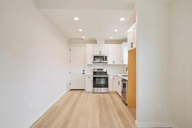 a large kitchen with stainless steel appliances granite countertop a stove and a refrigerator