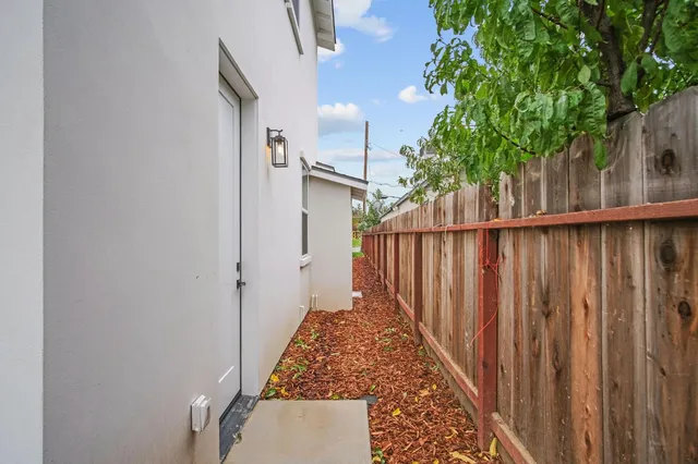 a view of a pathway of a house with wooden fence