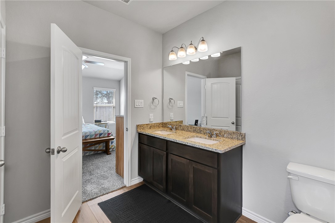 909 Davy Street Brenham, TX 77833 - Photo 20 of 35 Ensuite bathroom featuring double vanity and light wood-style flooring