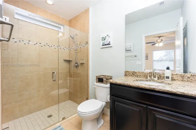 a bathroom with a granite countertop sink toilet and shower