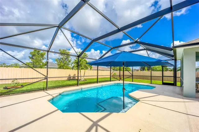 a view of pool with a chair and table