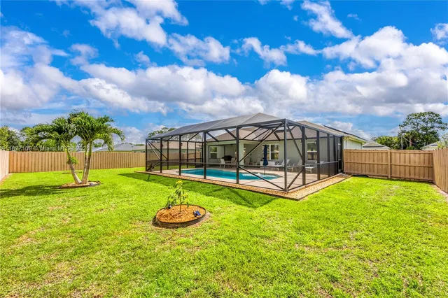 a view of backyard with swimming pool and seating