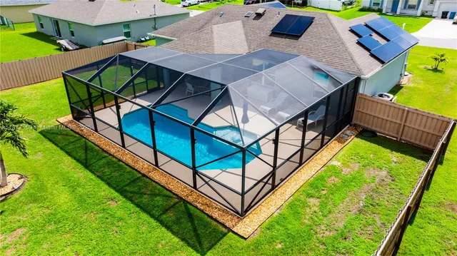 an aerial view of a house having swimming pool patio and backyard