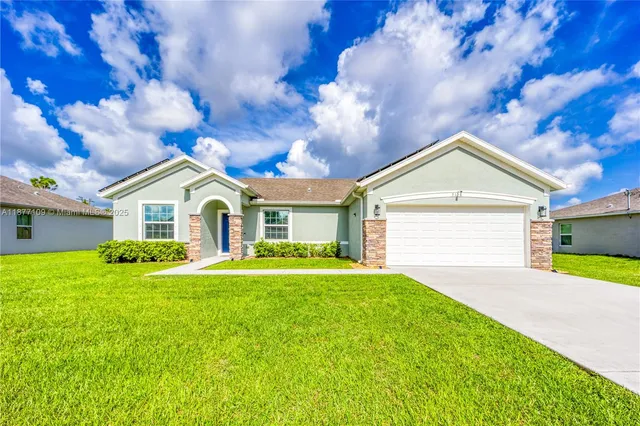 a front view of a house with yard and green space