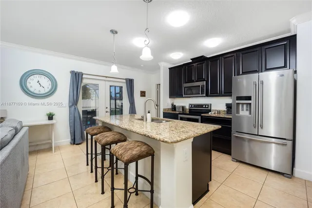 a kitchen with stainless steel appliances granite countertop a refrigerator a stove a sink a oven with a dining table and chairs