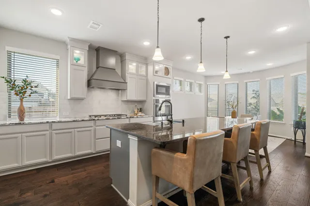 a kitchen with stainless steel appliances granite countertop a kitchen island a stove and a sink