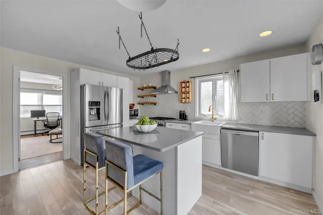 a kitchen with stainless steel appliances granite countertop a sink a stove and refrigerator