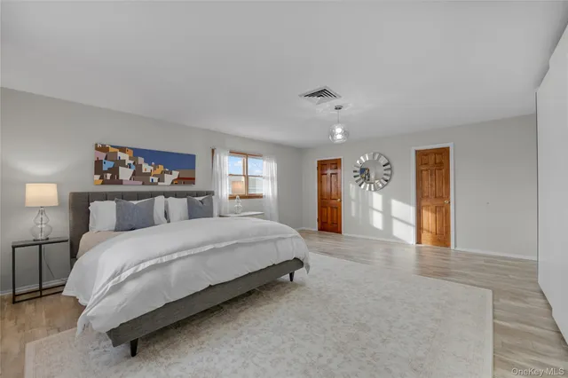 a spacious bedroom with a bed and glass windows