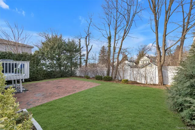 a view of a backyard with table and chairs and a tree