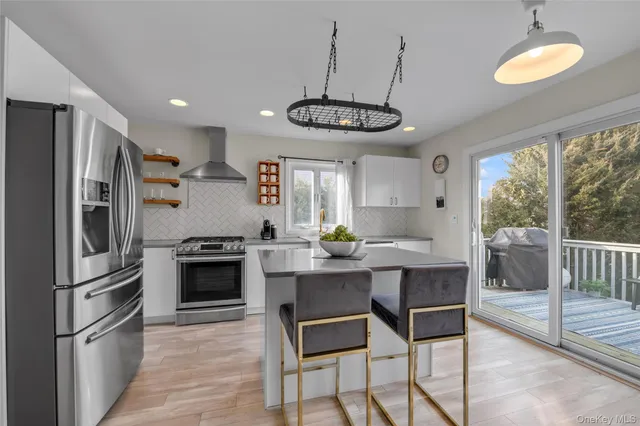 a kitchen with stainless steel appliances a table chairs refrigerator and microwave