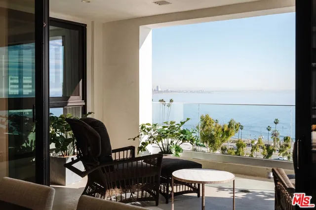 a view of a balcony with chairs and a potted plant