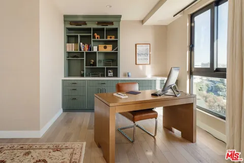 a bedroom with a bed flat screen tv and a large window