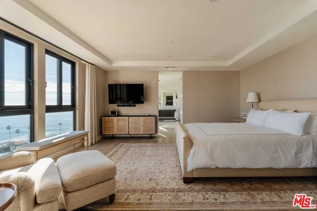 a spacious bedroom with a large bed and a large window