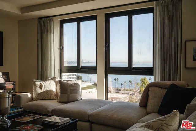a living room with furniture and large windows