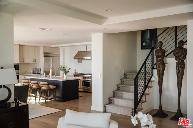 a view of kitchen with stainless steel appliances granite countertop living room and hallway