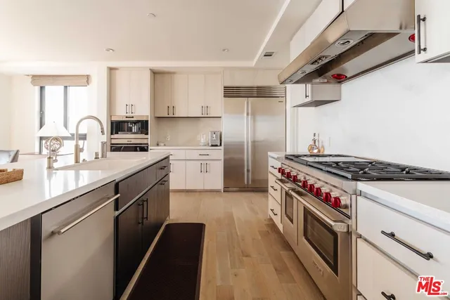 a kitchen with stainless steel appliances a sink stove and refrigerator