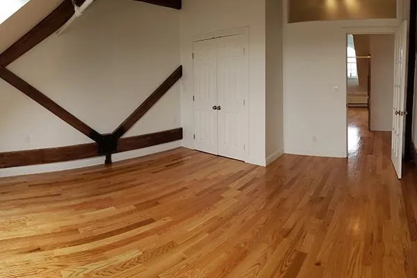 a view of an empty room with wooden floor