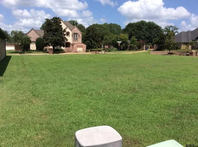 a view of a big yard with a house in the background