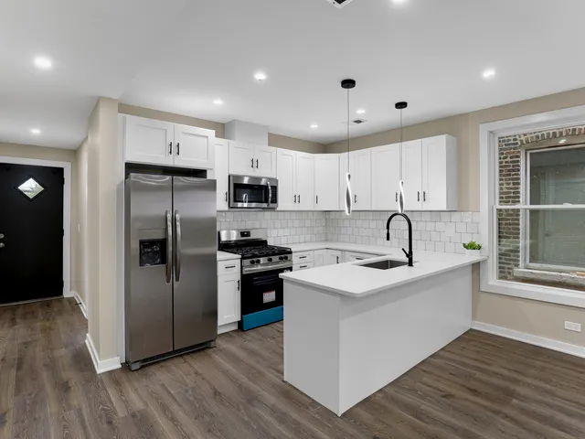 a kitchen with stainless steel appliances a stove a sink a microwave and cabinets