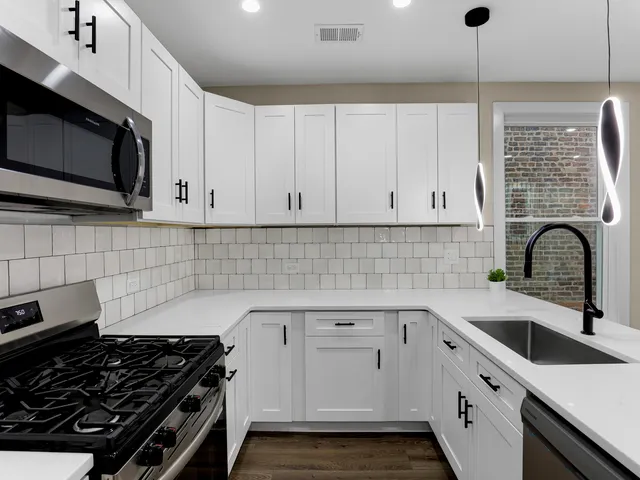 a view of a kitchen with a refrigerator and a stove top oven