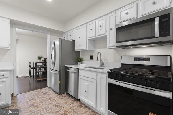 a kitchen with stainless steel appliances granite countertop a refrigerator stove and microwave