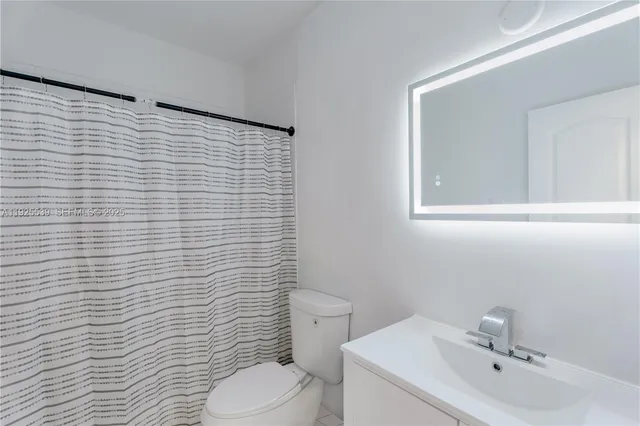 a bathroom with a sink a toilet and mirror