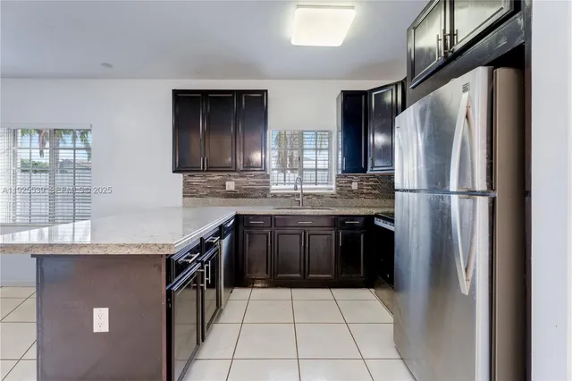 a kitchen with stainless steel appliances granite countertop a refrigerator and a sink