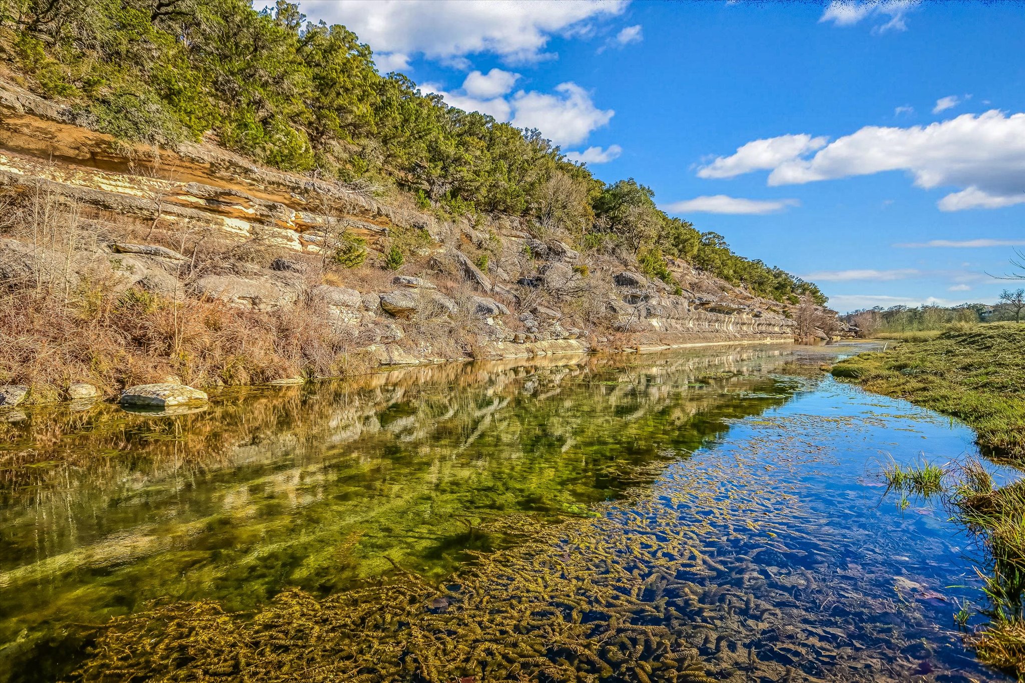 4698 Fischer Store Road Wimberley, TX 78676 - Photo 4 of 28 Clear flowing water reflects the rugged limestone cliffs and wooded hillsides of this scenic property.