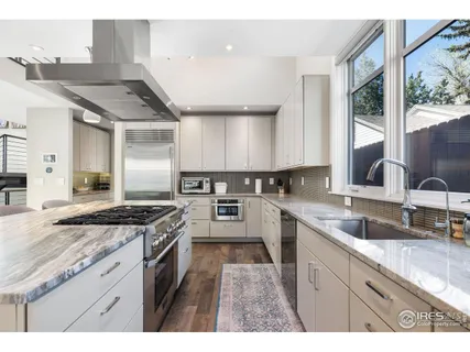 a kitchen with granite countertop a sink stove and cabinets