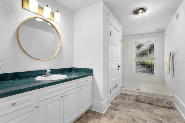 a bathroom with a granite countertop sink and a mirror