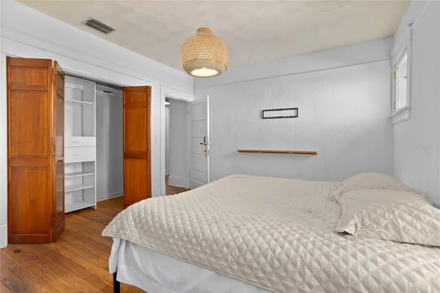 a bedroom with a bed and wooden floor