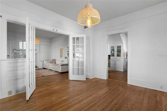 a view of a livingroom with wooden floor and a kitchen space
