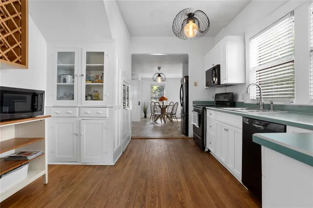 a kitchen with wooden floors and appliances