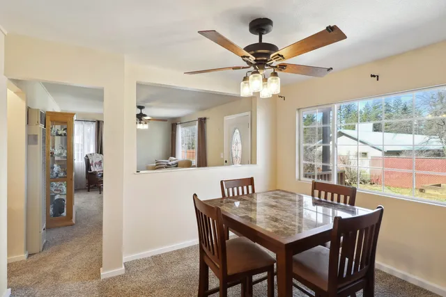 a dining room with wooden floor a chandelier a wooden table and chairs