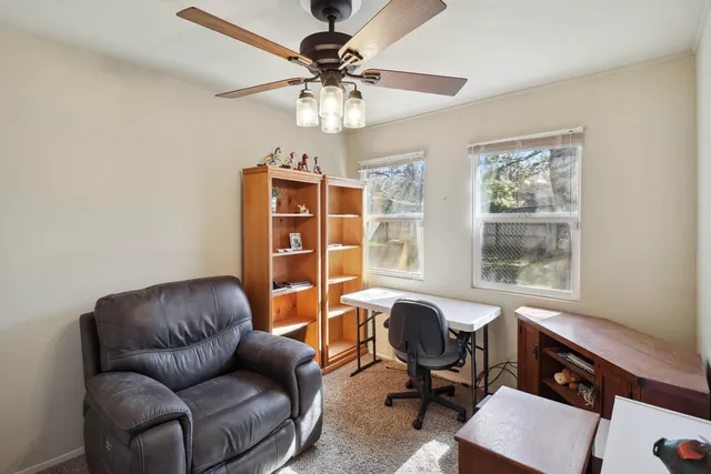 a view of a livingroom with workspace and a window