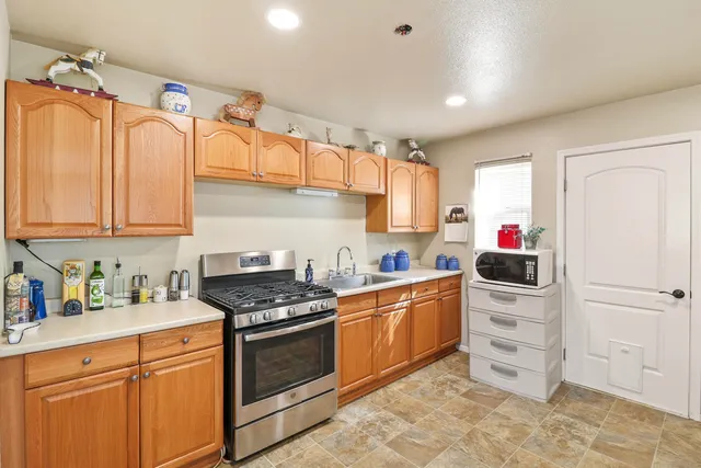 a kitchen with stainless steel appliances white cabinets and a stove top oven