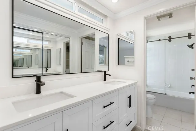a bathroom with a sink and mirror with bathtub