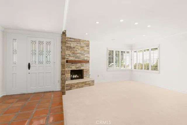 a view of an empty room with a fireplace and a window