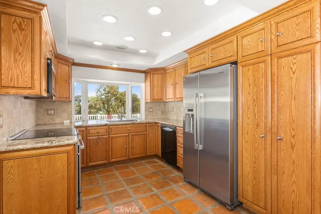a kitchen with stainless steel appliances granite countertop a refrigerator and a sink