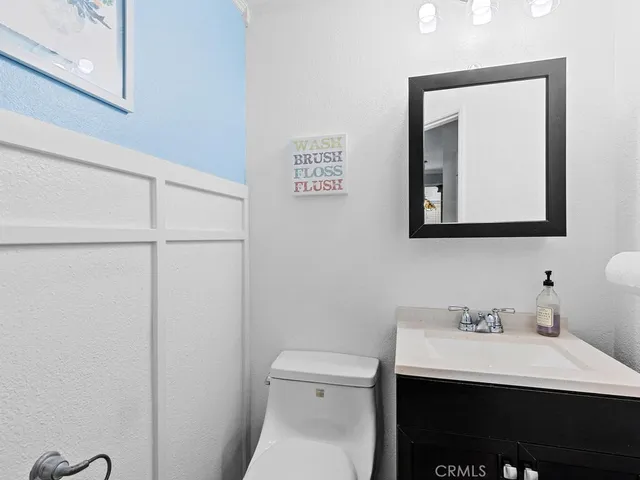 a bathroom with a toilet a sink and mirror