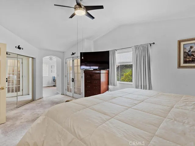 a large bedroom with a bed and a flat screen tv